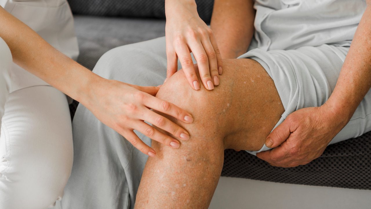 Provider examining a patient's knee for joint pain at Westbroek Family Medicine