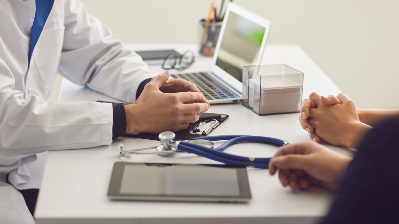 Family doctor talking with a patient across a desk at Westbroek Family Medicine